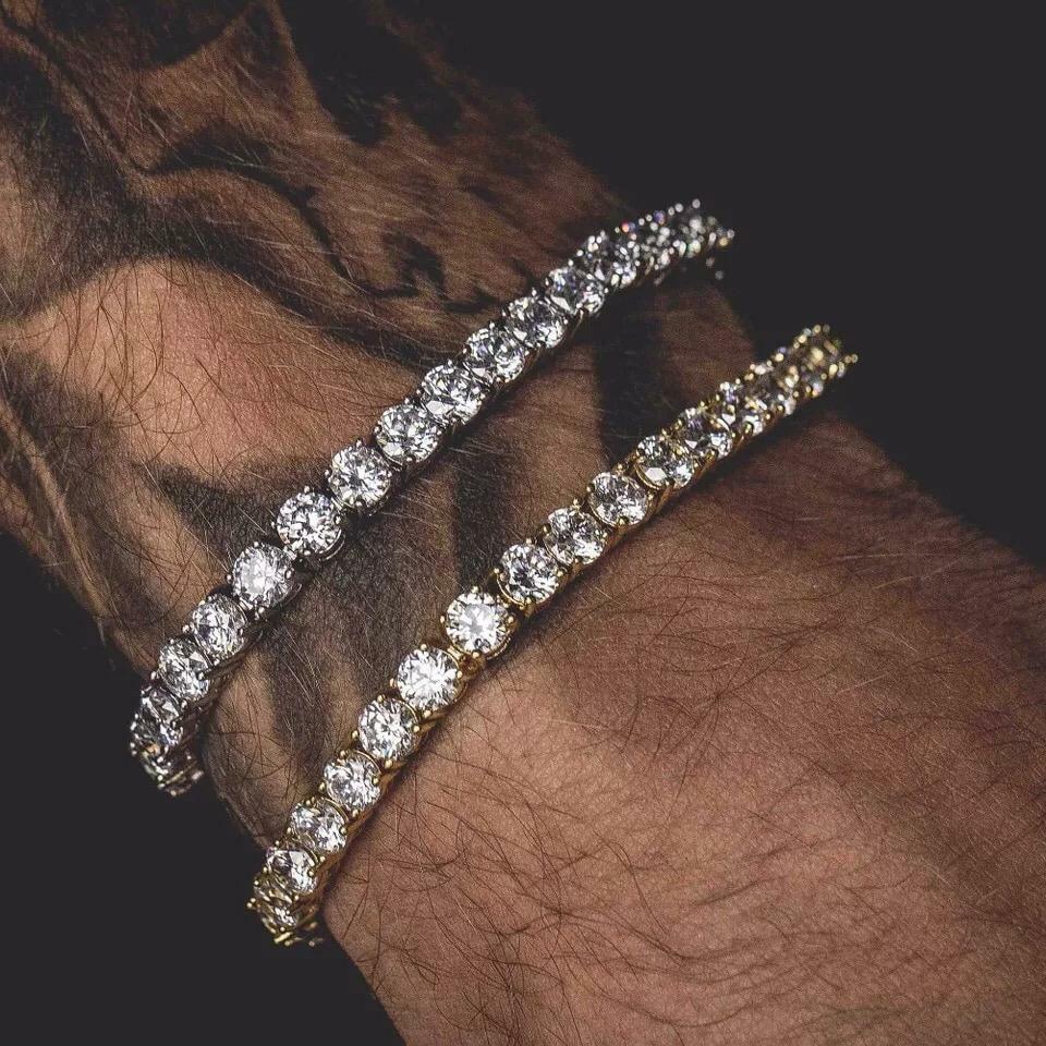 Two shining diamond bracelets, one silver and one gold, resting on a tattooed wrist.